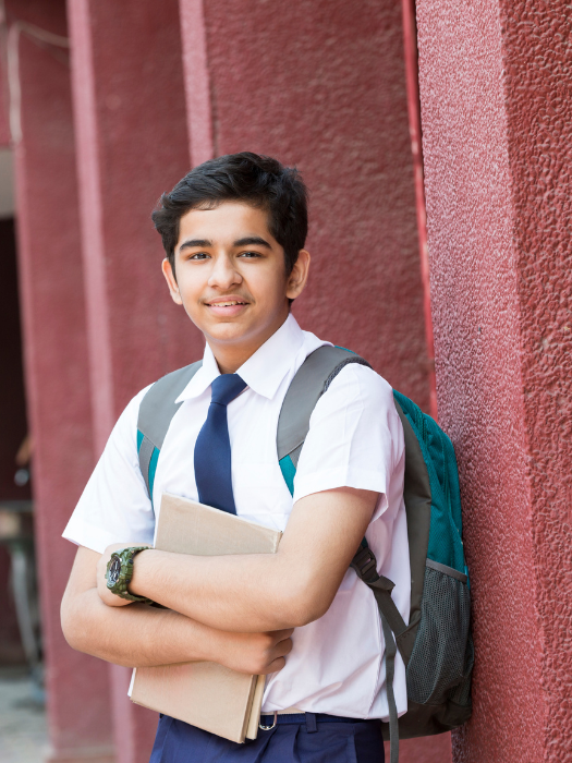 Student with school uniform and backpack representing aspiring science students preparing for PCMB coaching