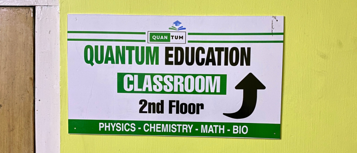 Quantum Education classroom direction sign for physics, chemistry, mathematics and biology coaching in Guwahati.