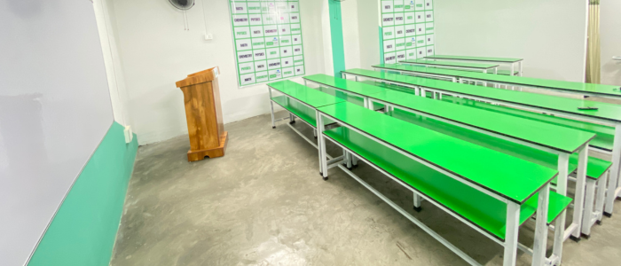 Modern PCMB classroom with green benches and whiteboard at Quantum Education coaching institute in Guwahati.